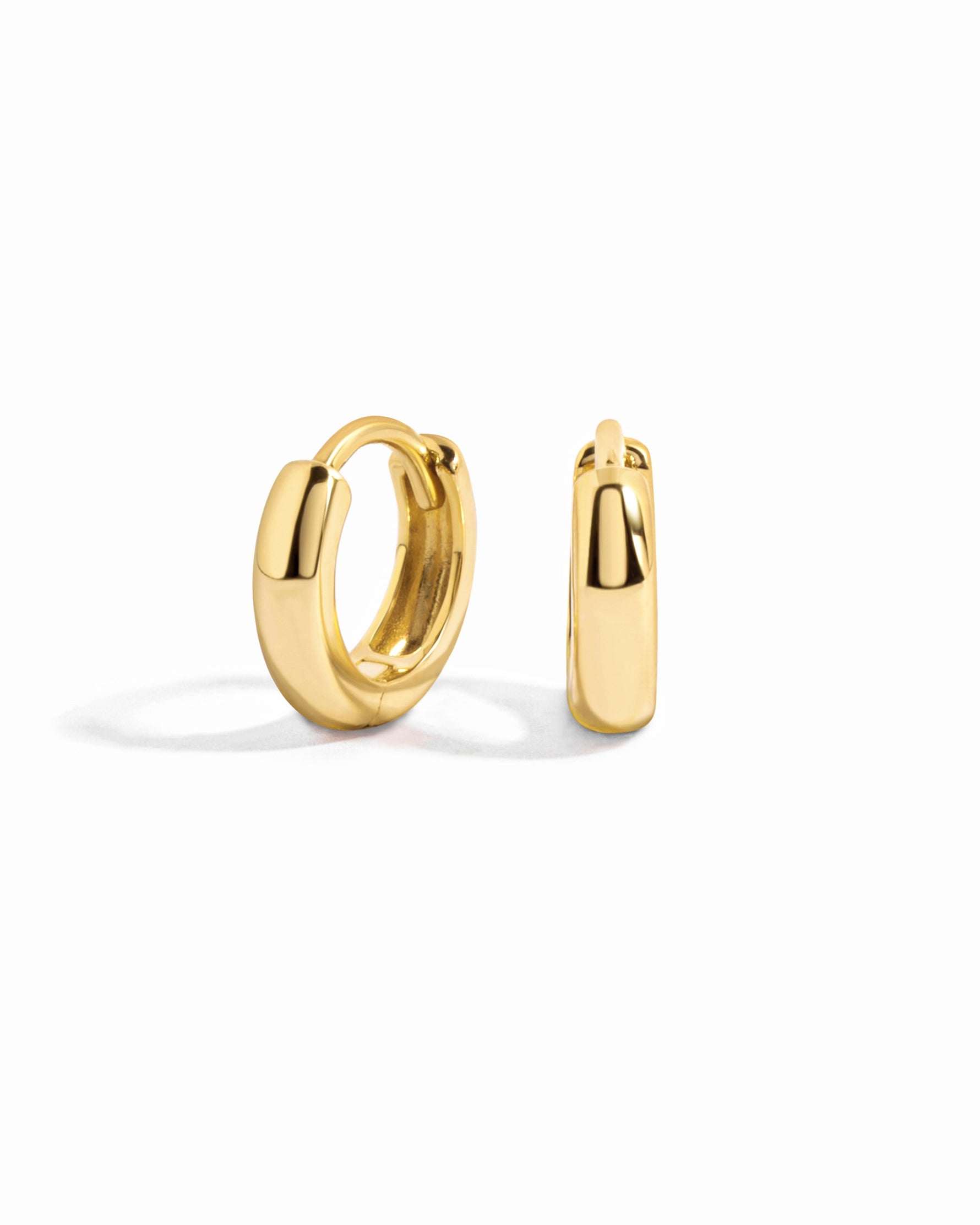 Gold minimalist huggie earrings by Sami Jewels displayed on a white background.