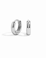 Sterling silver minimalist huggie earrings by Sami Jewels on a white background. Small, sleek hoop earrings with a modern design.