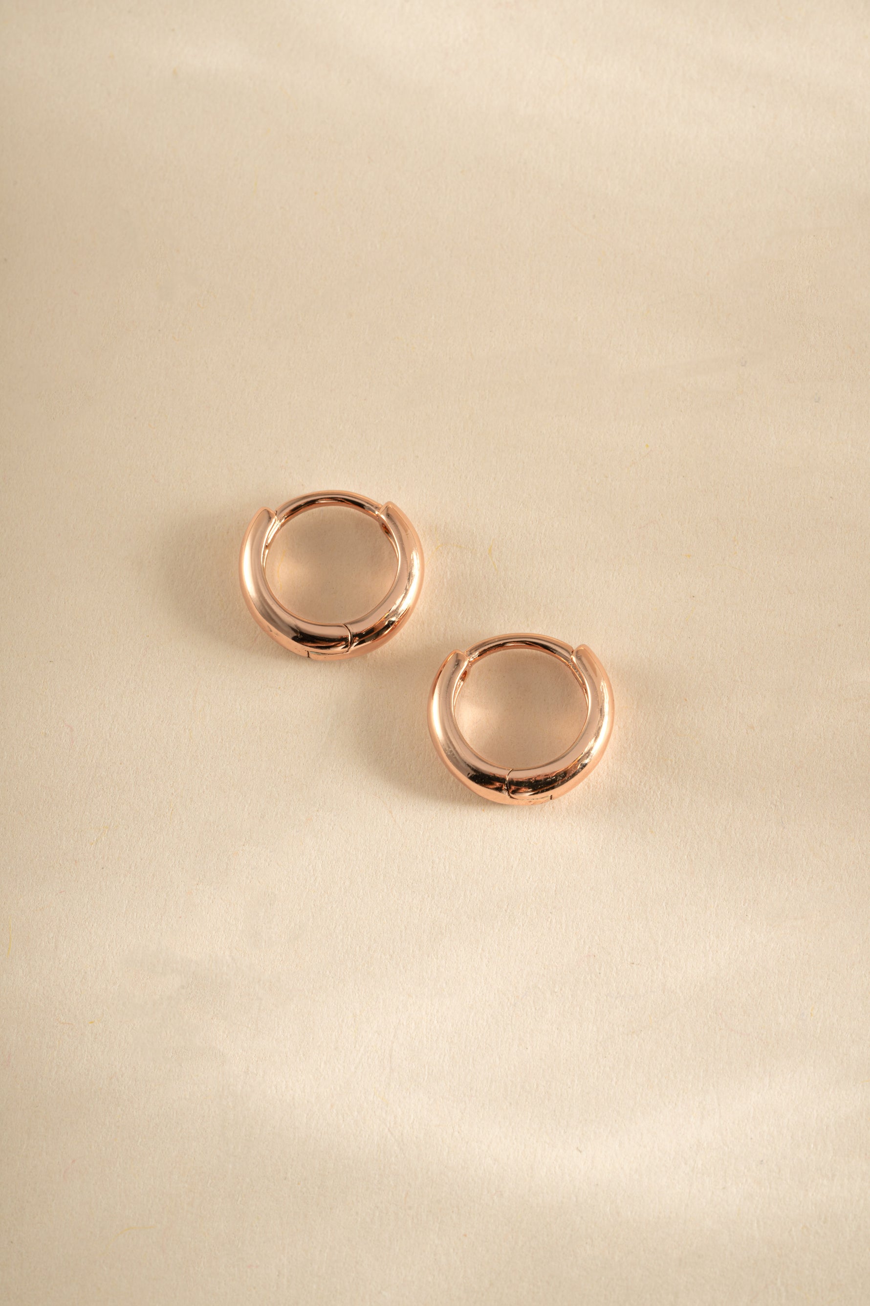 Rose gold Sami Jewels minimalist huggie hoop earrings with sleek, simple design perfect for everyday wear.