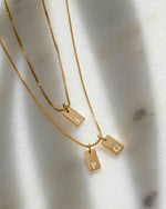 Gold initial tag necklace from Sami Jewels, featuring a dainty personalized pendant on a delicate chain.