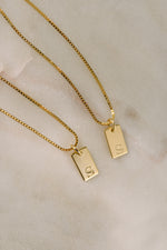 Gold initial tag necklace from Sami Jewels featuring a dainty, personalized initial pendant on a delicate chain.