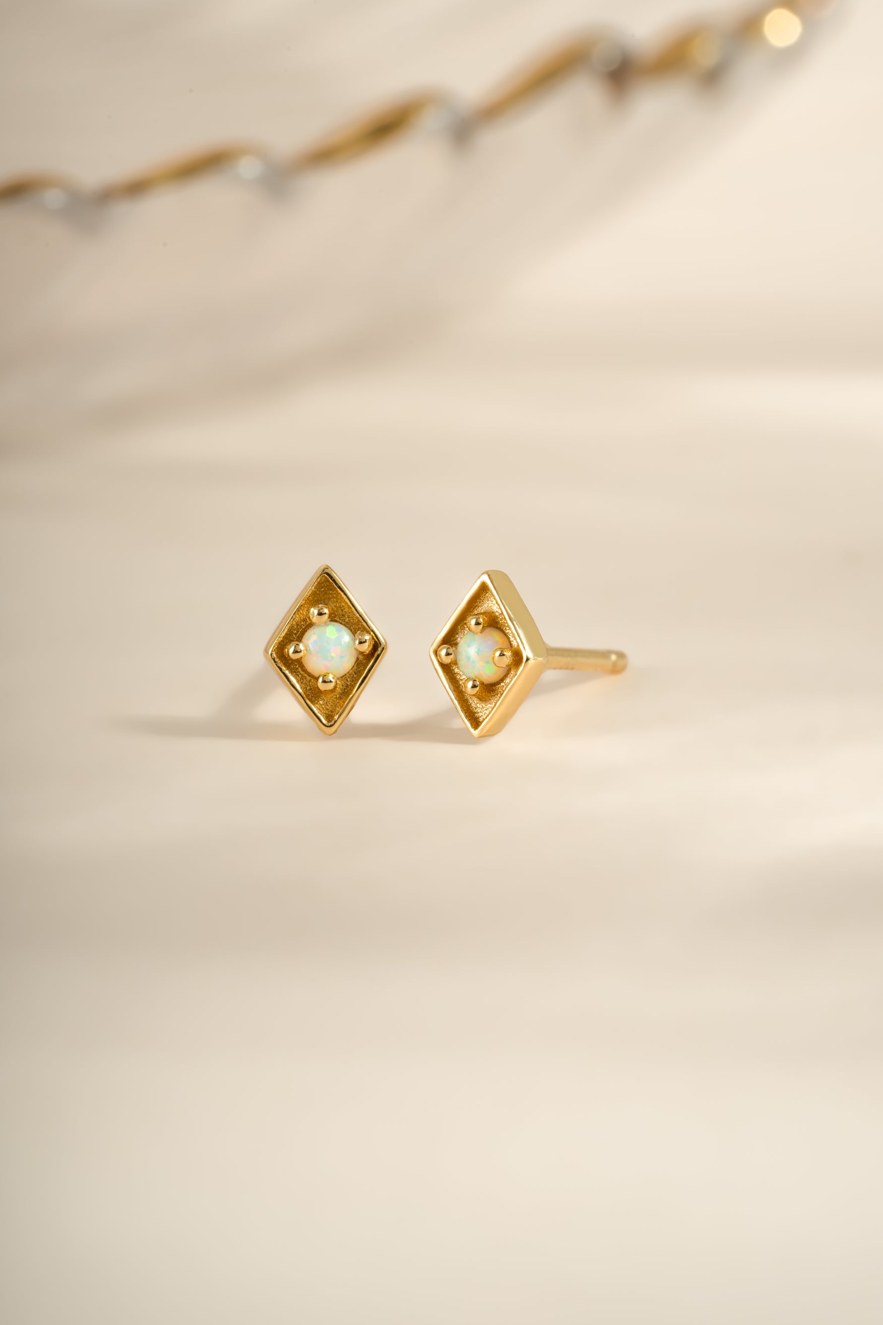 Gold kite-shaped opal stud earrings by Sami Jewels featuring vibrant, smooth gemstone designs.