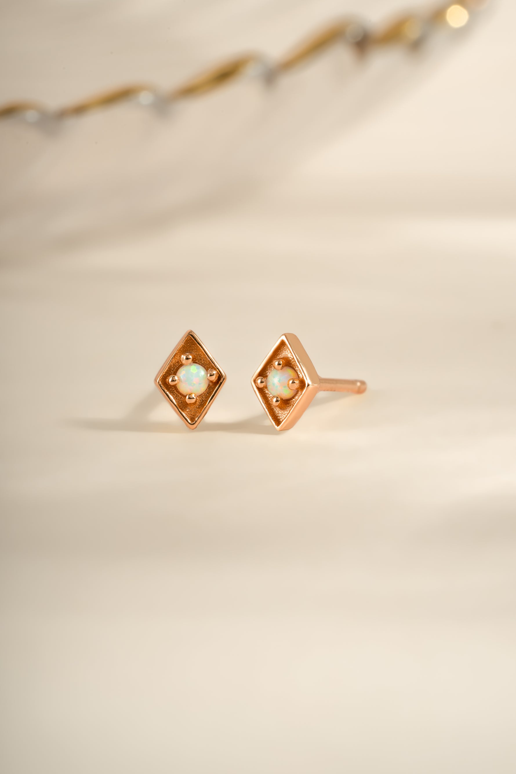 Rose gold kite-shaped opal stud earrings by Sami Jewels with vibrant, iridescent gemstone in a sleek, modern design.