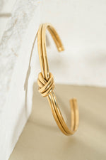 Gold stainless steel SS knotted bangle bracelet from Sami Jewels with a sleek, waterproof design.