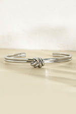 Silver stainless steel SS knotted bangle bracelet by Sami Jewels, featuring a stylish knotted cuff design.