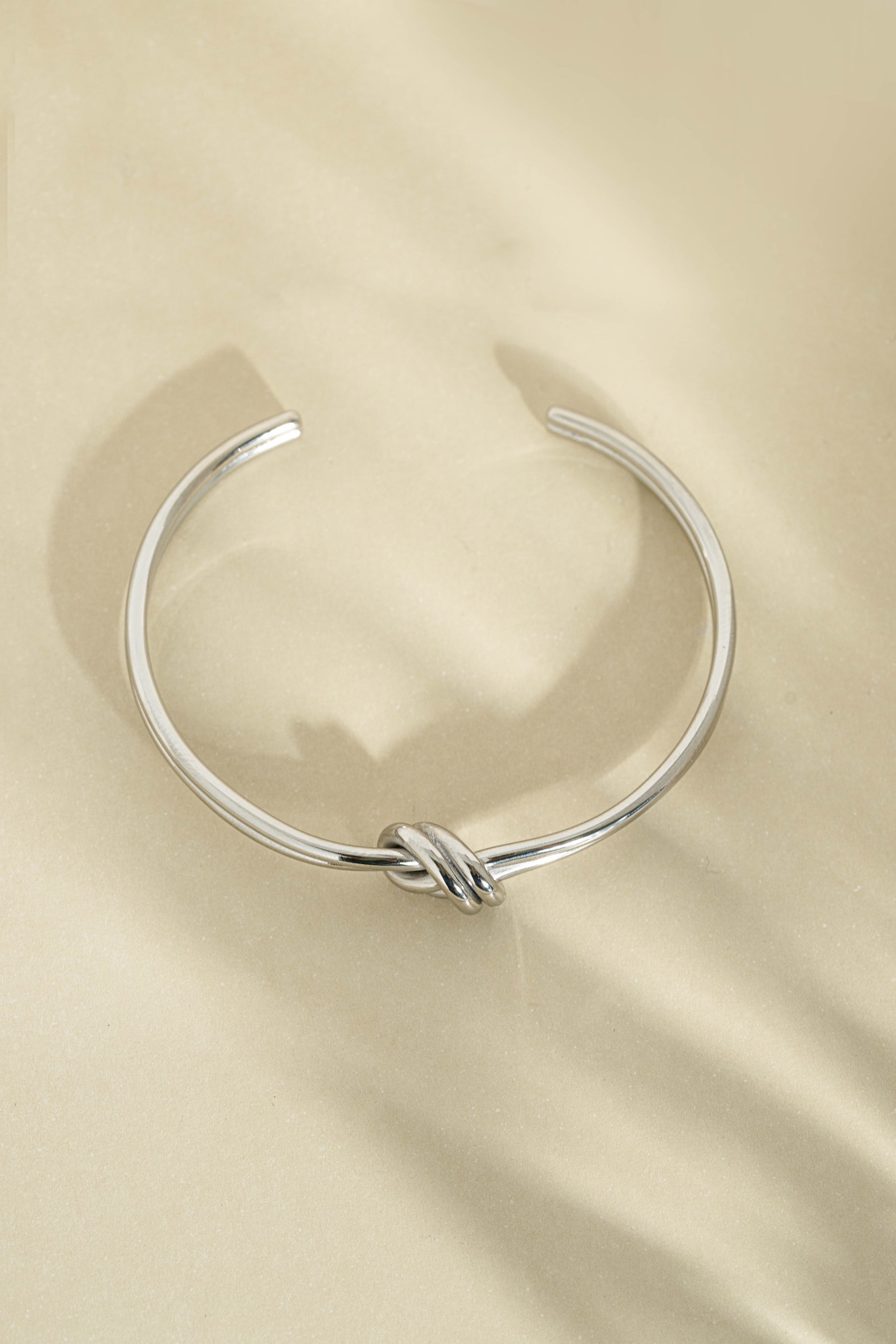 Silver stainless steel SS knotted bangle bracelet with a stylish knotted design, waterproof and durable for everyday wear.