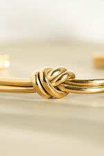 Gold stainless steel SS knotted bangle bracelet by Sami Jewels, stylish cuff design with a knot detail and waterproof finish.