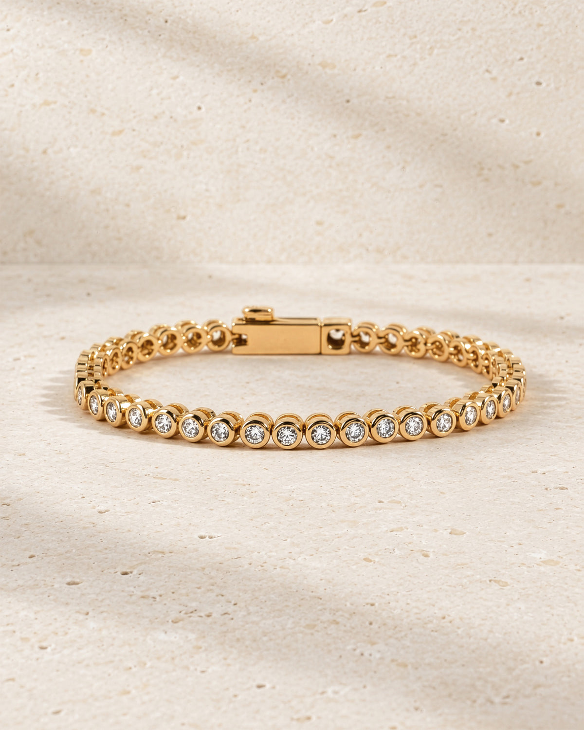 Lab-grown diamond round bezel tennis bracelet in gold vermeil with the clasp closed