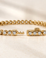 Lab-grown diamond round bezel tennis bracelet with the box clasp open