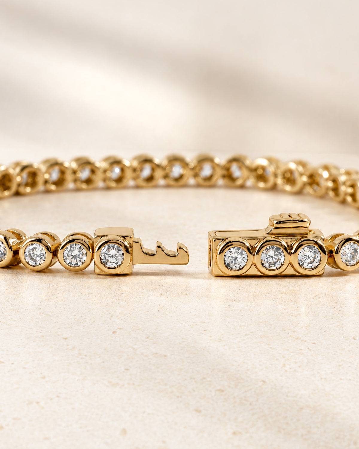 Lab-grown diamond round bezel tennis bracelet with the box clasp open
