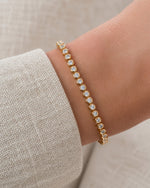 Lab-grown diamond round bezel tennis bracelet in gold vermeil worn alone on the wrist