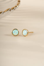Gold large opal stud earrings by Sami Jewels featuring round, iridescent gemstones on a simple, elegant setting.
