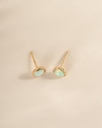 Large opal stud earrings by Sami Jewels, gold setting with a top view of the sparkling, round gemstone studs.