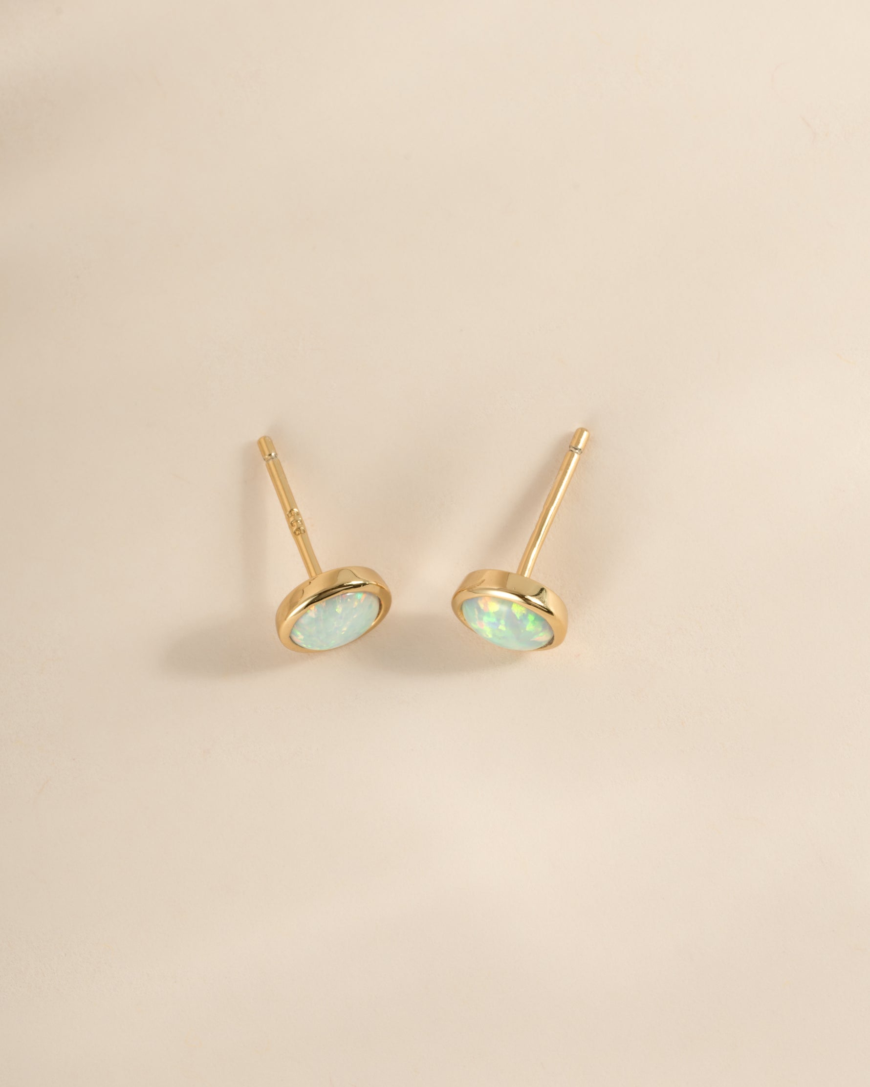 Large opal stud earrings by Sami Jewels, gold setting with a top view of the sparkling, round gemstone studs.