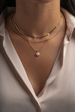 Layered gold necklaces with the mariner chain