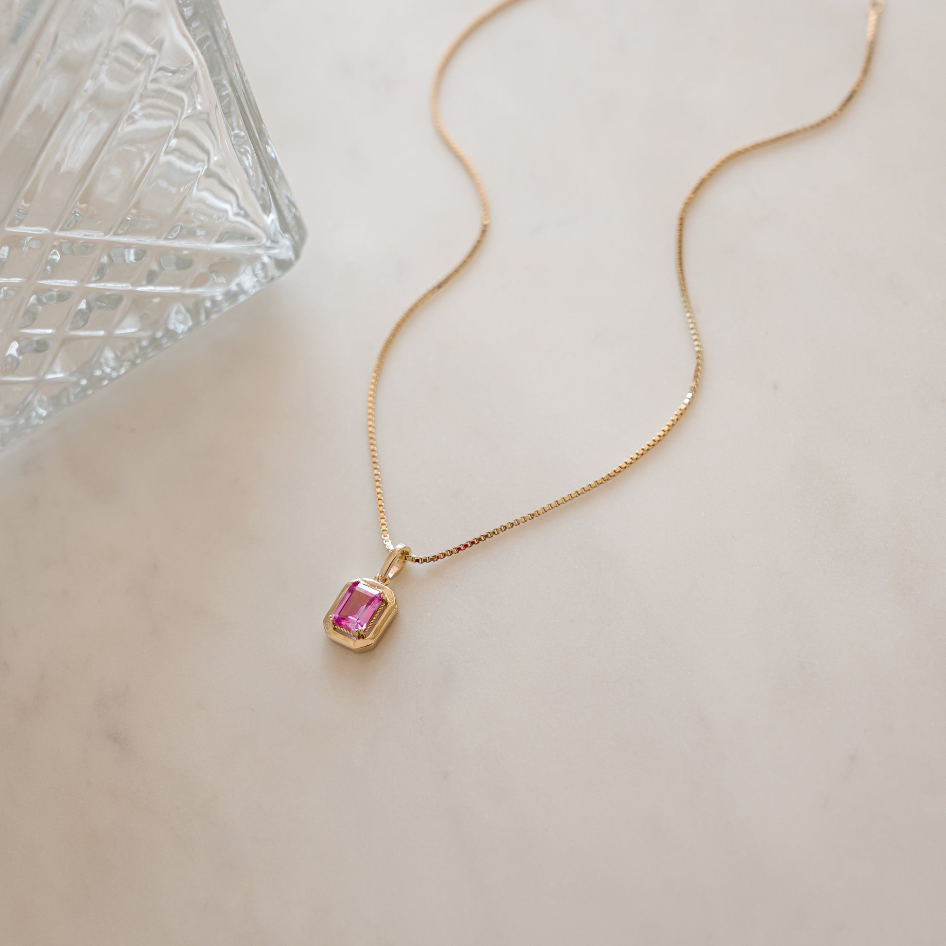 dainty gold layering necklace with pink baguette stone