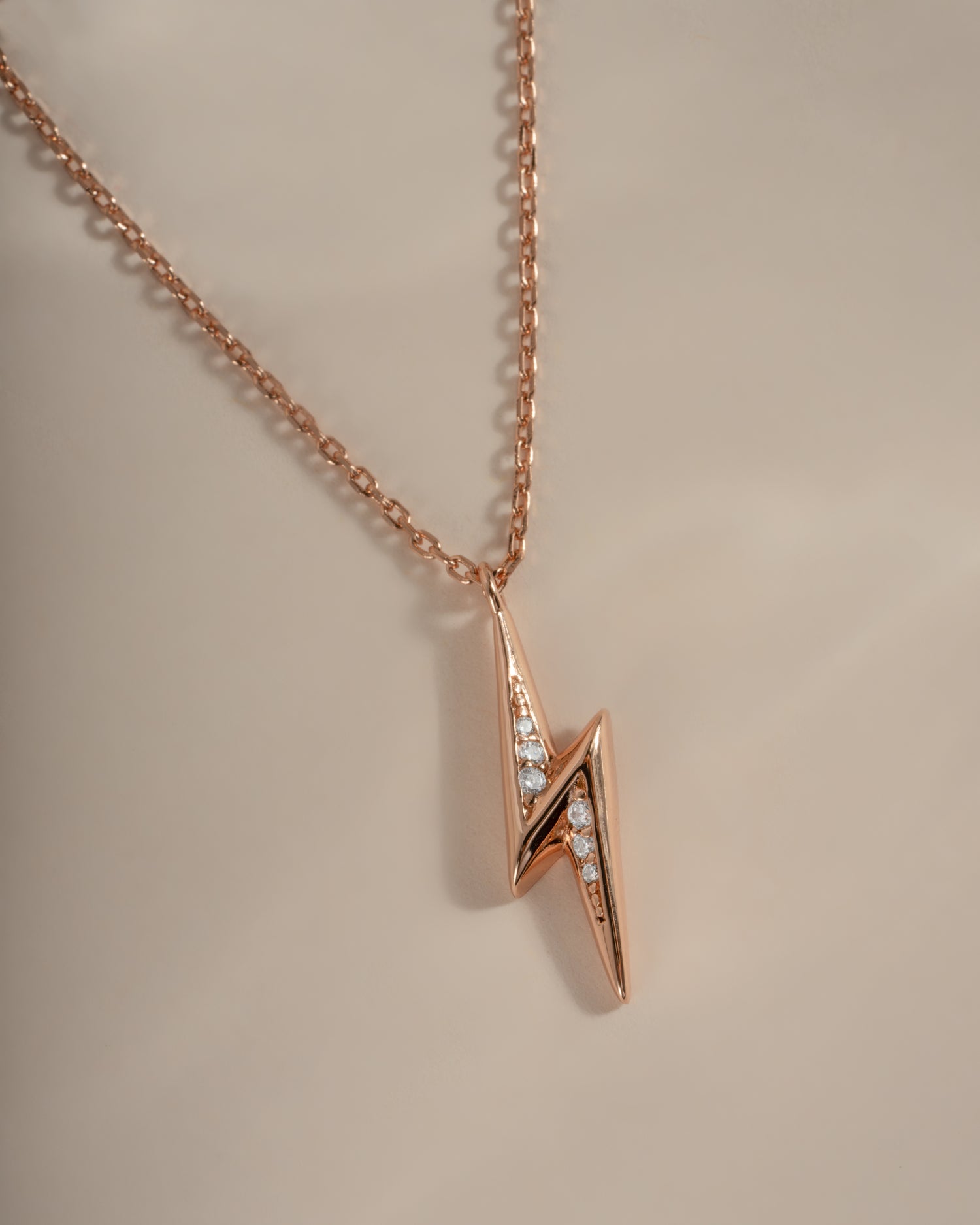 Close-up of Sami Jewels rose gold lightning bolt necklace, showcasing its sleek design and shiny finish.