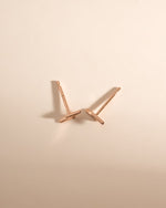 Rose gold lightning bolt stud earrings by Sami Jewels, top view showing sleek lightning bolt design and shiny finish.