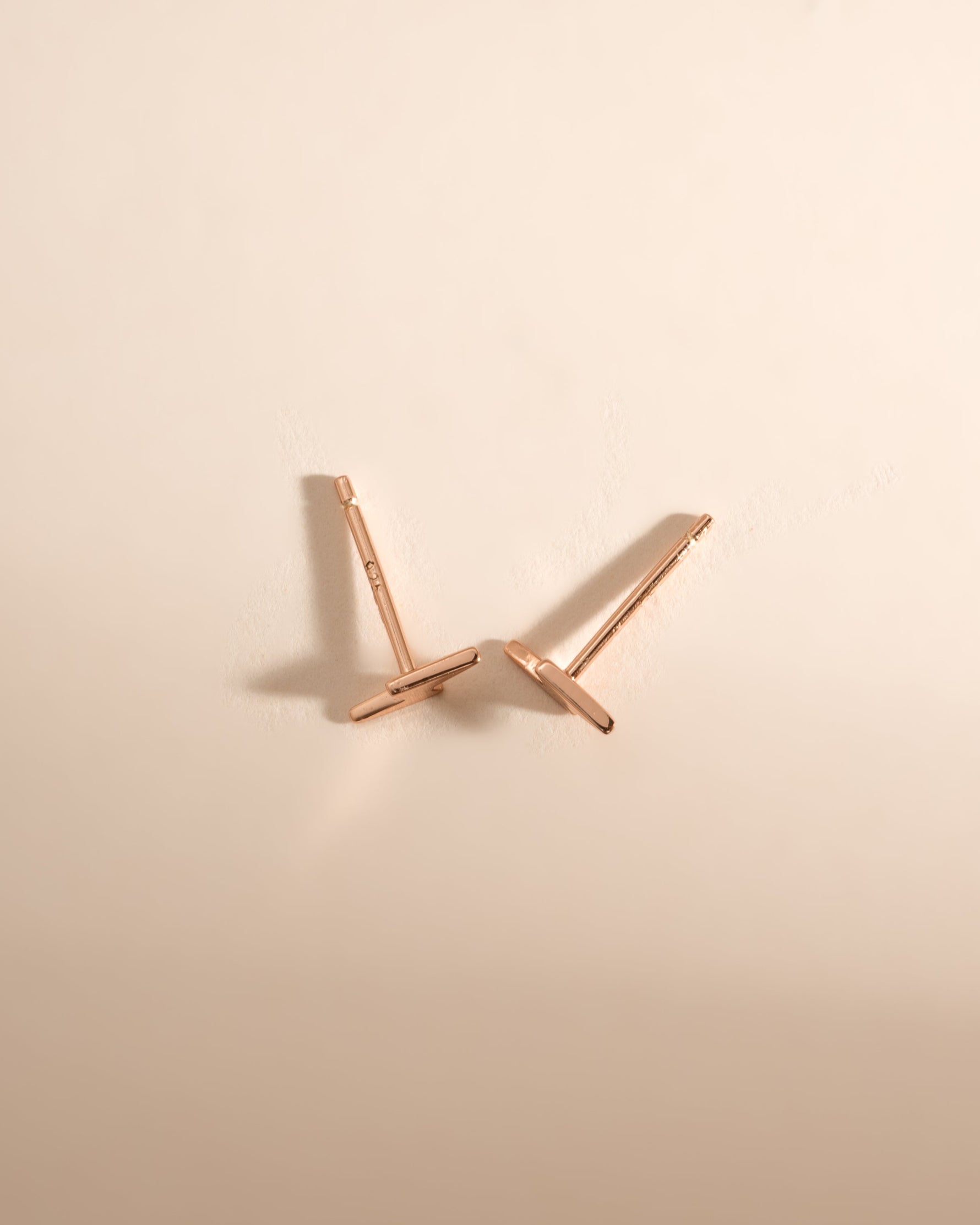 Rose gold lightning bolt stud earrings by Sami Jewels, top view showing sleek lightning bolt design and shiny finish.