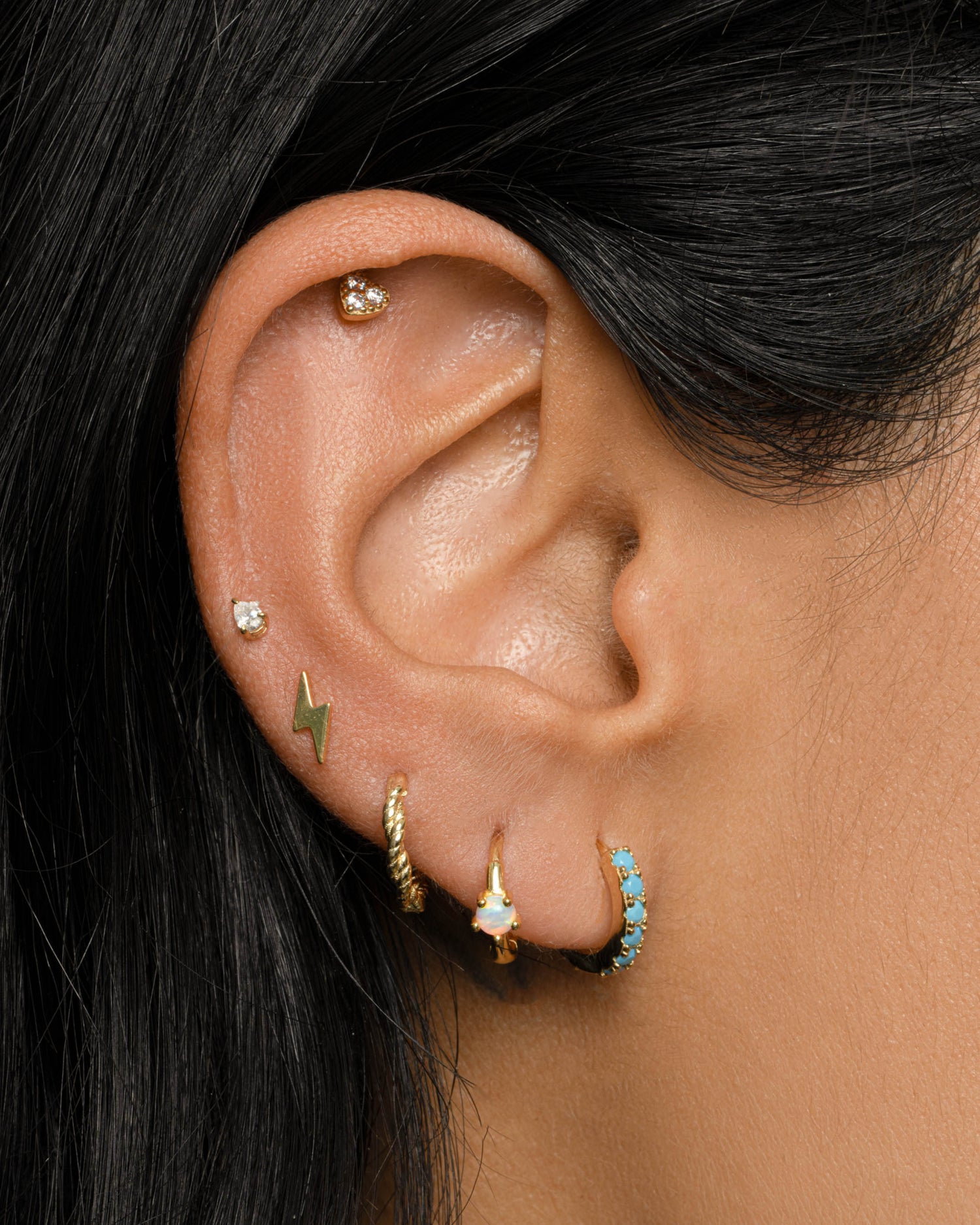 Gold lightning bolt stud earrings by Sami Jewels, featuring sleek, modern lightning bolt design on a model.