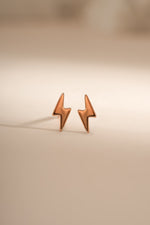 Rose gold lightning bolt stud earrings by Sami Jewels, featuring sleek, modern lightning bolt design in a close-up shot.
