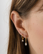 Sami Jewels marquise bezel drop huggie earrings worn on a model, featuring elegant marquise-shaped design and gold-tone finish.