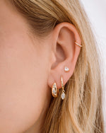 Gold Sami Jewels Marquise Bezel Drop Huggie earrings stacked on ear, featuring marquise-shaped bezels and hoop design.
