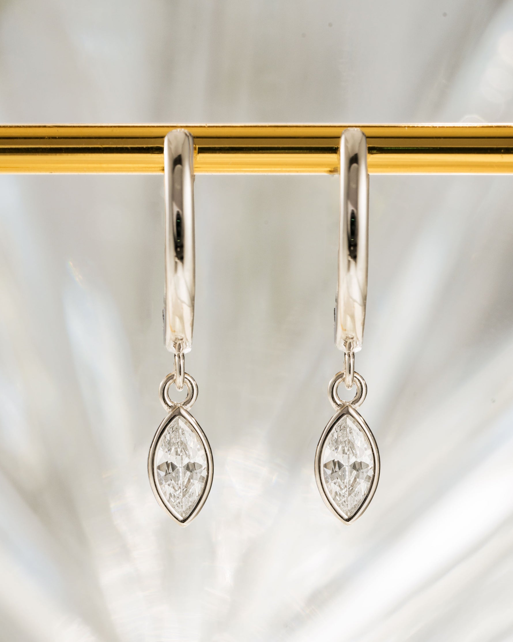 Sterling silver Marquise Bezel Drop Huggies earrings featuring bezel-set marquise-shaped stones and hoop design.