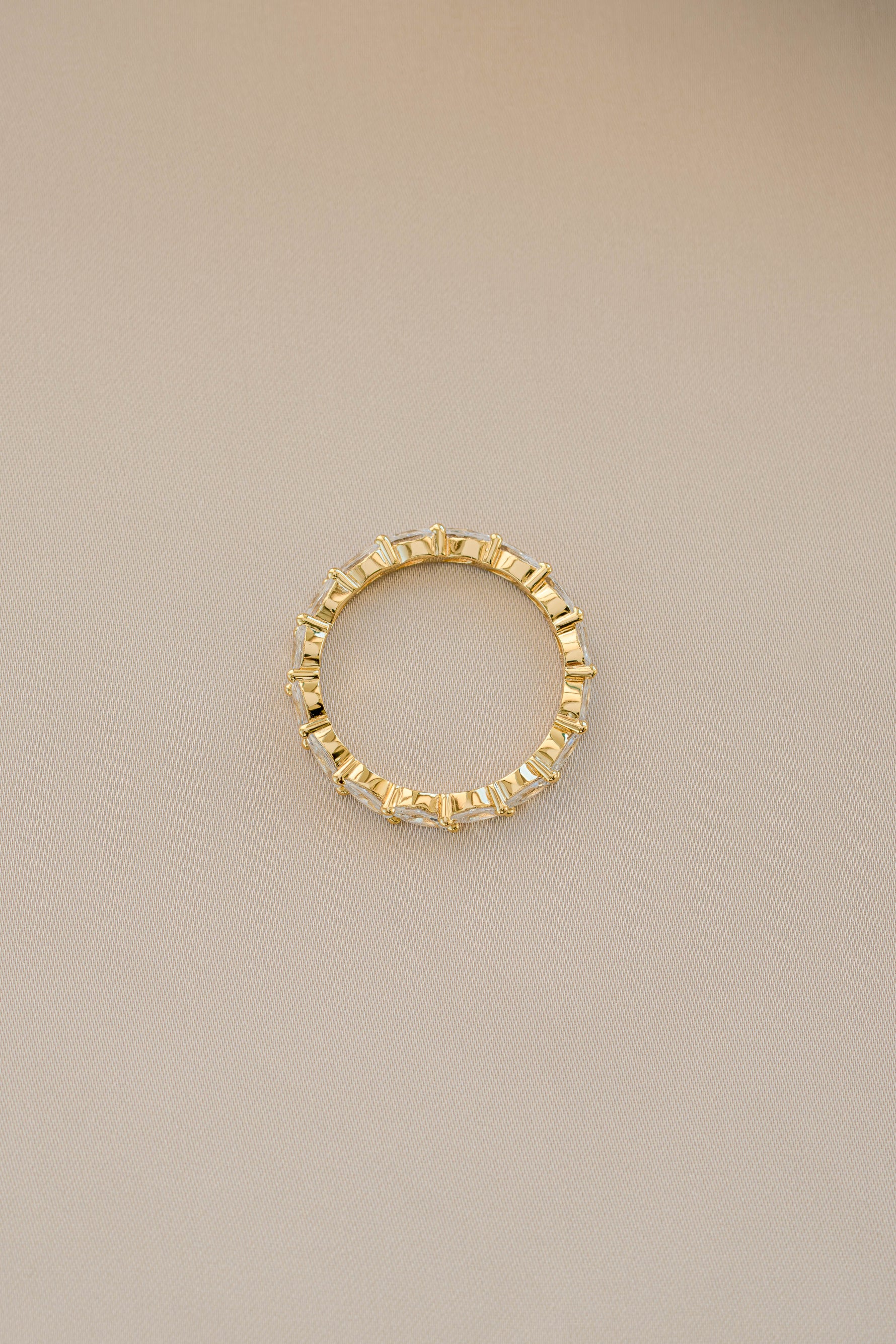 Gold Marquise Eternity Ring by Sami Jewels, showcasing a sleek band with marquise-shaped gemstones in a continuous design.