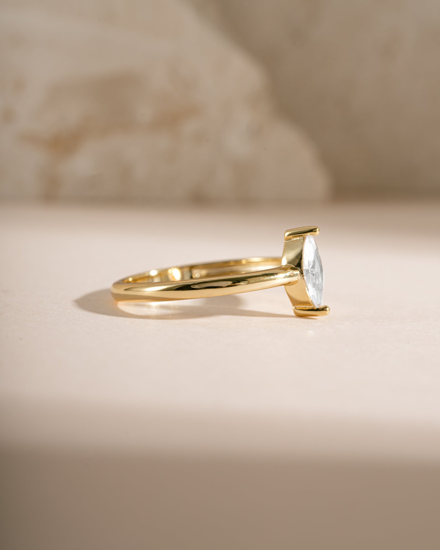 Gold solitaire marquise ring by Sami Jewels, side view displaying its elegant marquise-shaped gemstone and sleek band.