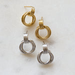 flat lay of gold and silver knot hoop earrings, showcasing delicate yet bold intertwined knot detail.