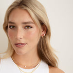 model wearing small hoops with diamond huggies