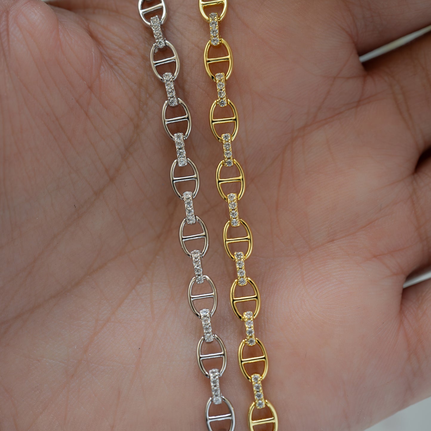 Close up of silver and gold diamond chain bracelets on hand