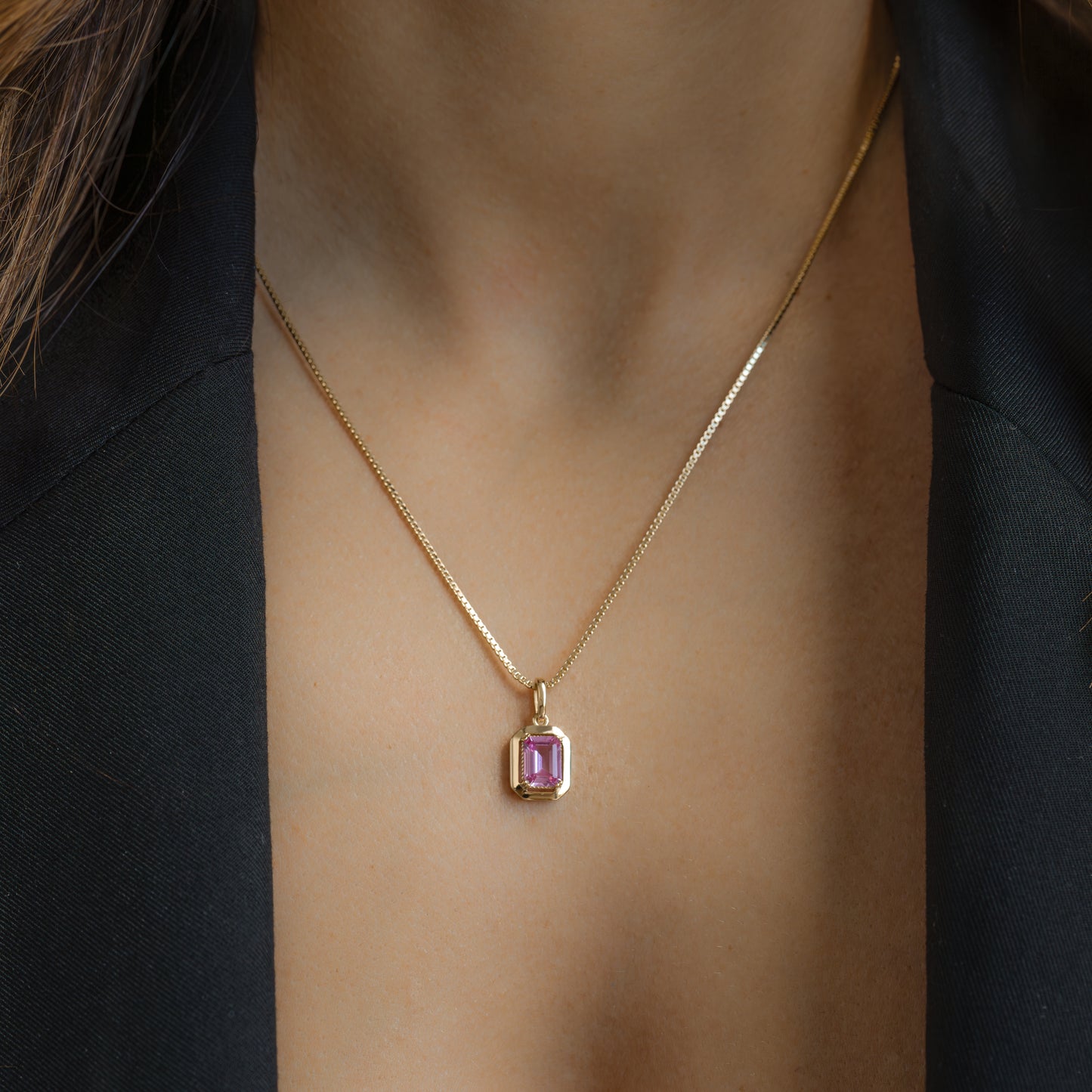 model wearing gold pink stone pendant necklace on box chain