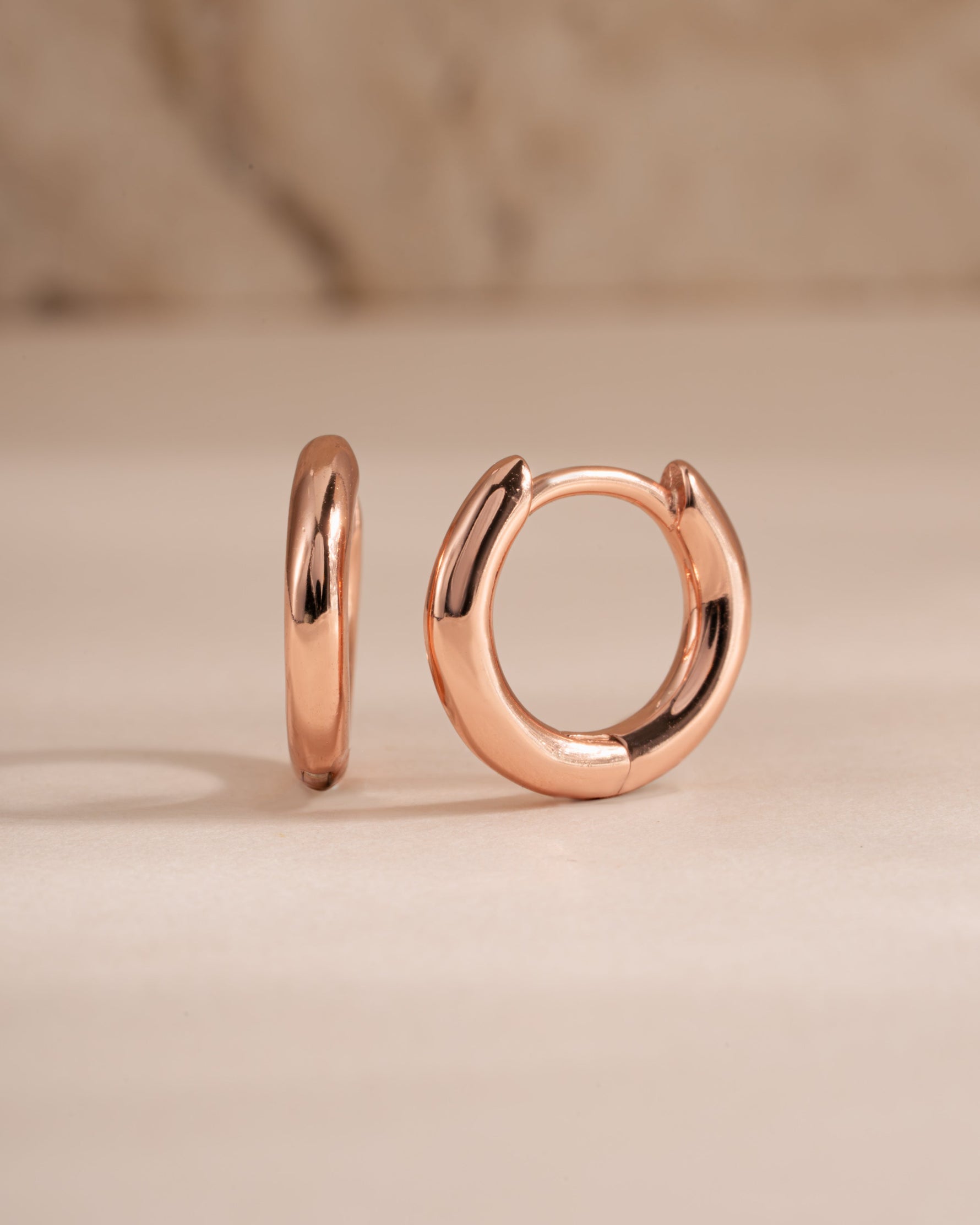 Rose gold 8mm minimalist small hoop earrings by Sami Jewels, shown from a side view on a clean background