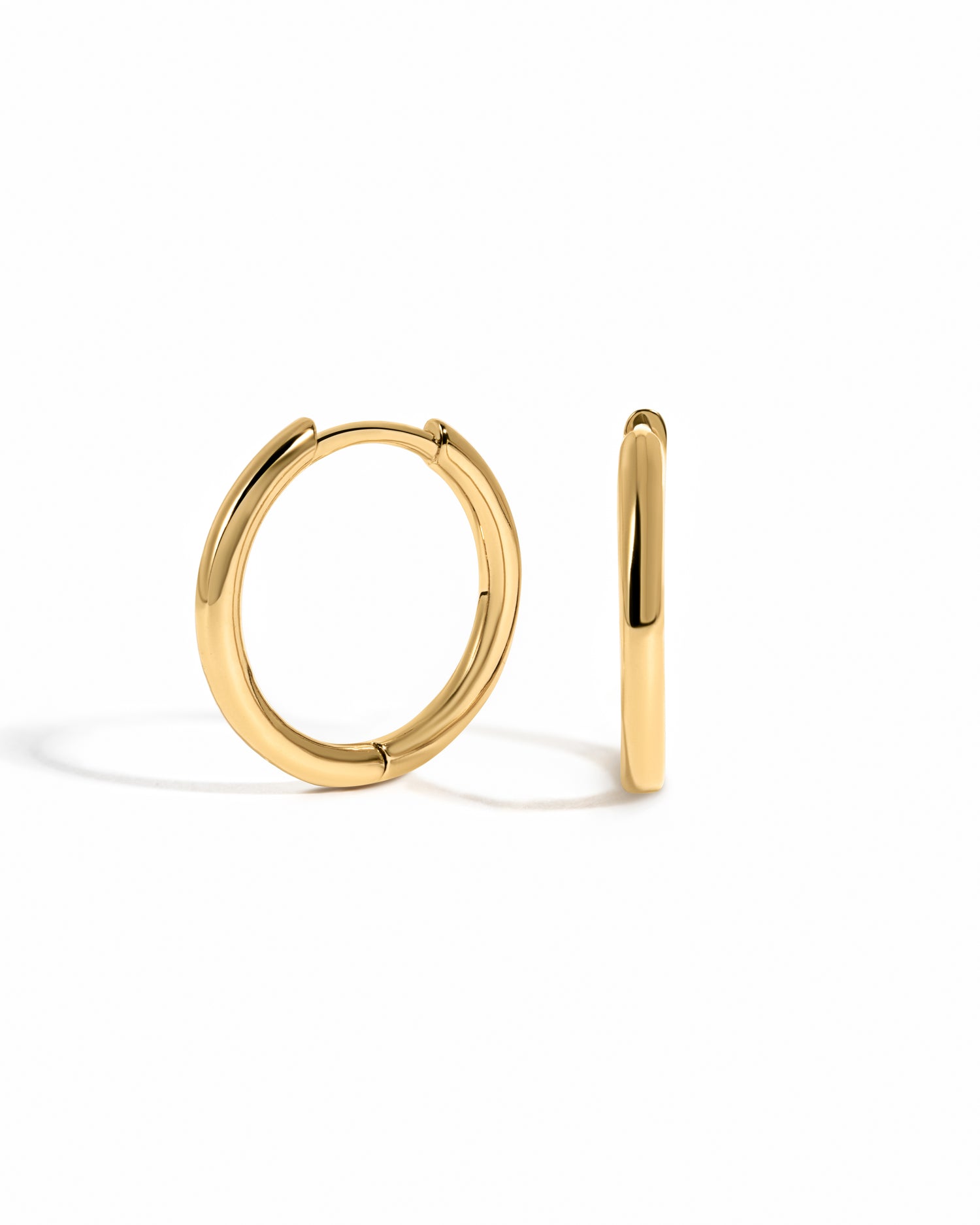 minimalist small gold hoop earrings white background