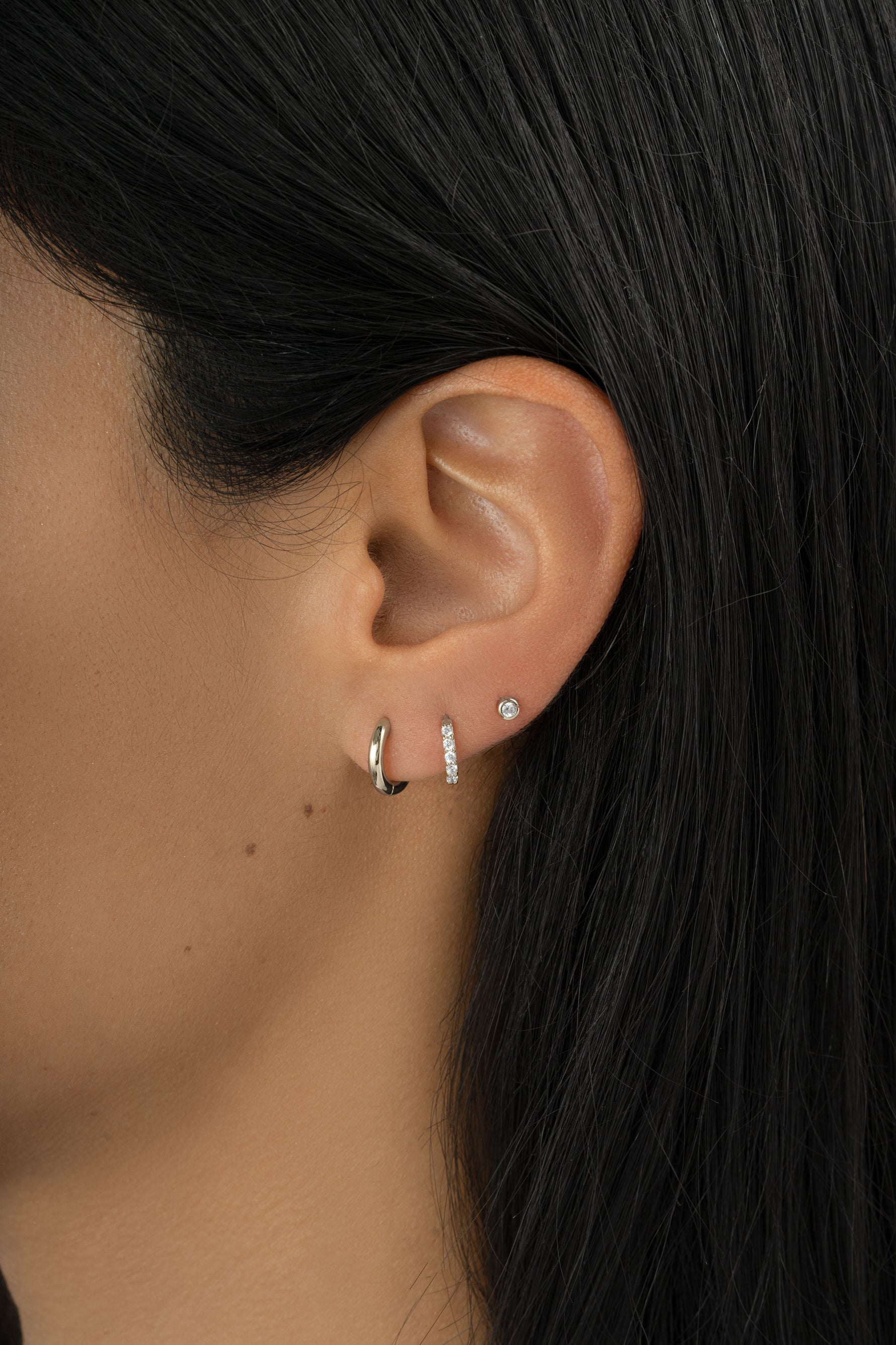Sterling silver Simple Huggie Hoops earrings by Sami Jewels, minimalist hoop design on a model.
