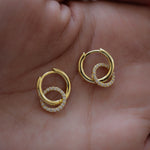 held on palm, close up of Hoop earrings with a round pavé pendant, lightweight and smooth. 