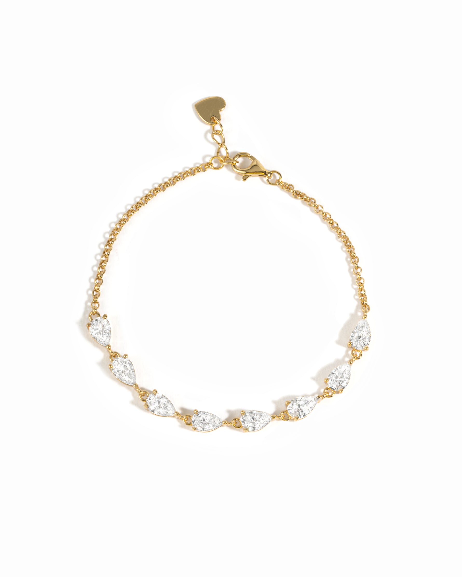 A delicate gold chain bracelet featuring a row of pear-cut cubic zirconia stones in a gold setting, with a small gold heart charm at the clasp, shown on a plain white background.