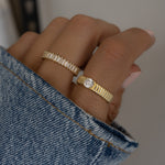 Model wearing textured solitaire ring on the index finger paired with matching minimalist ring on the middle finger. 