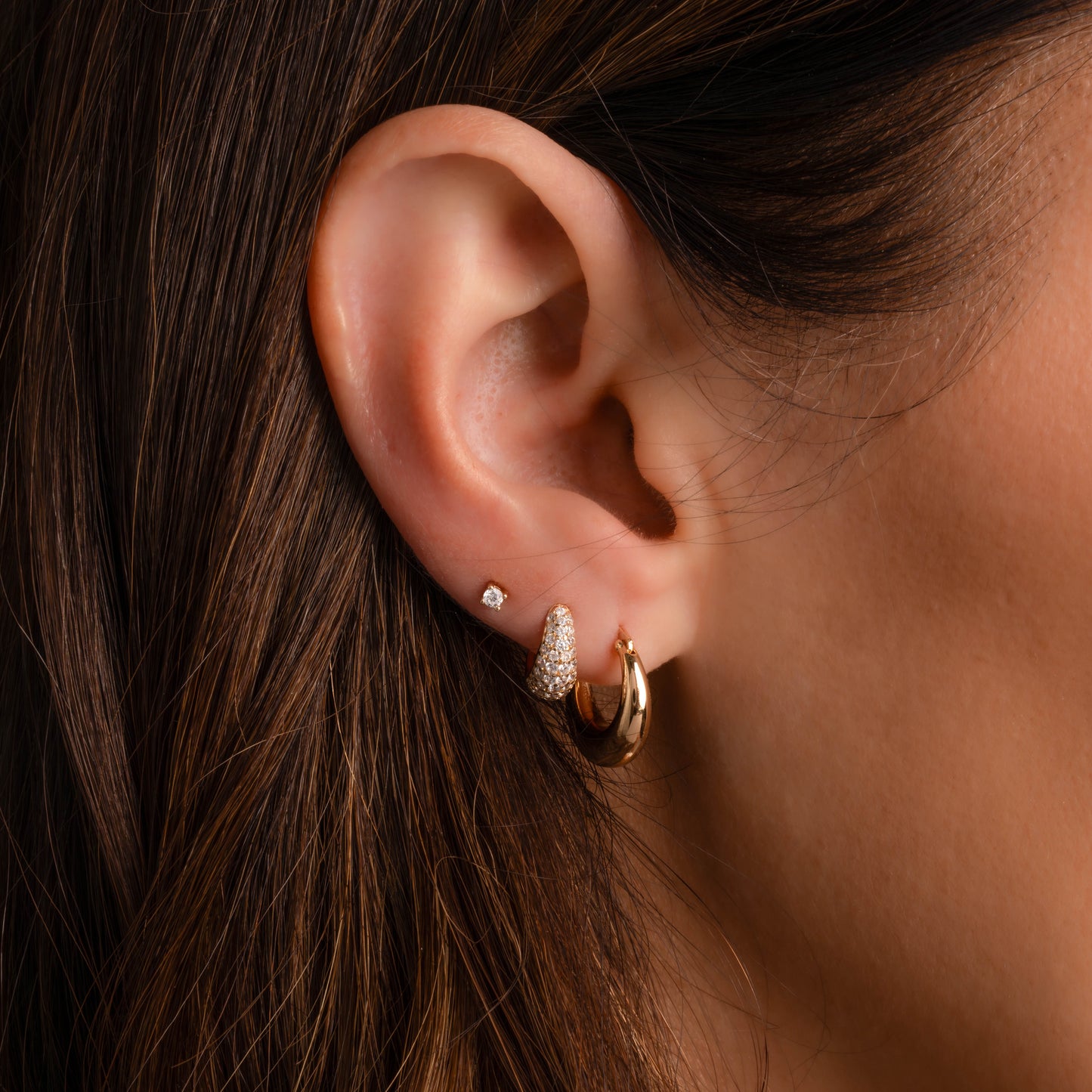 Minimalist Small Hoop Earrings with pave diamonds shown on model wearing other gold hoops and tiny diamond stud earrings