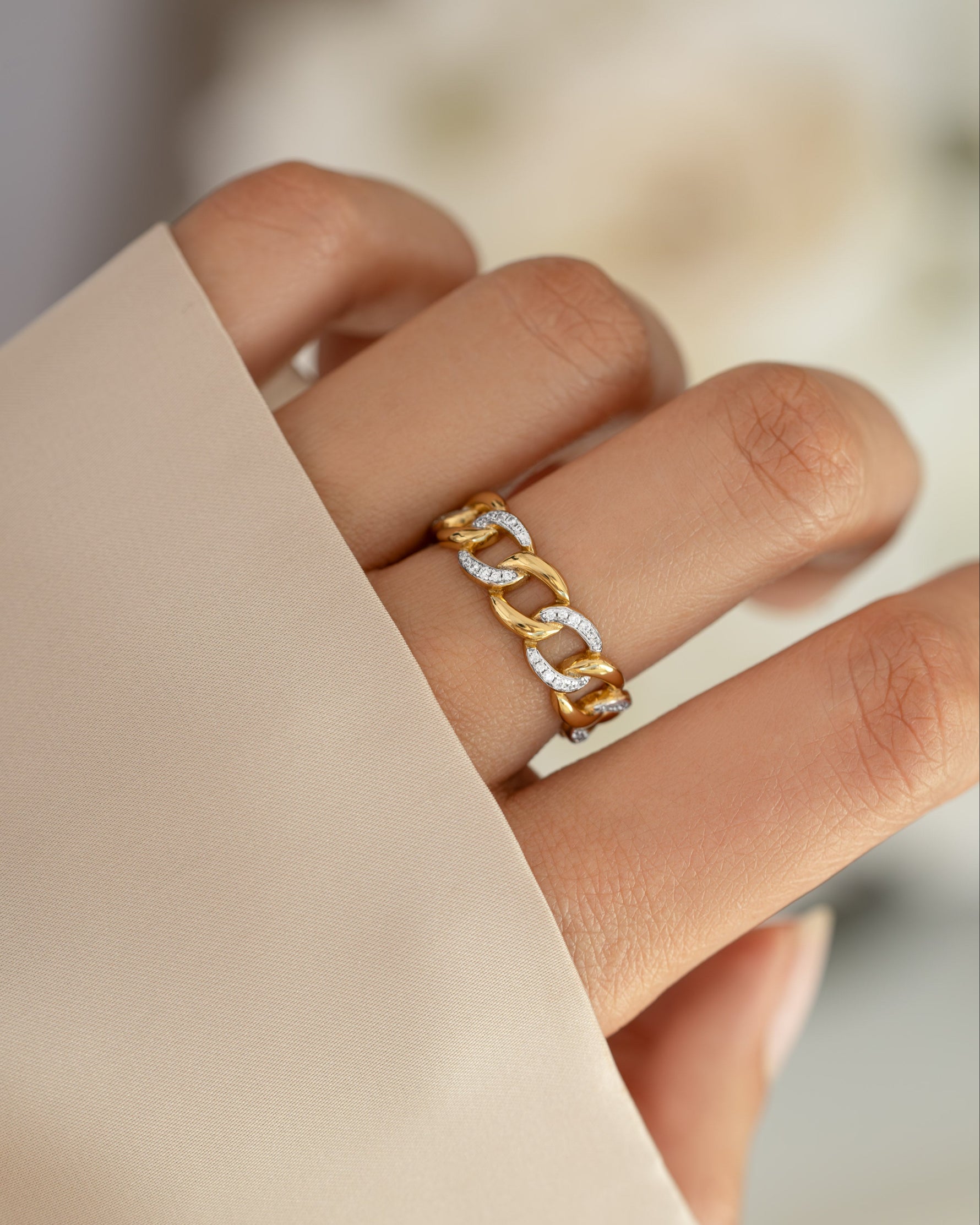 Gold and silver mixed-metal pavé chain ring from Sami Jewels, showcasing intricate design on a model's finger.