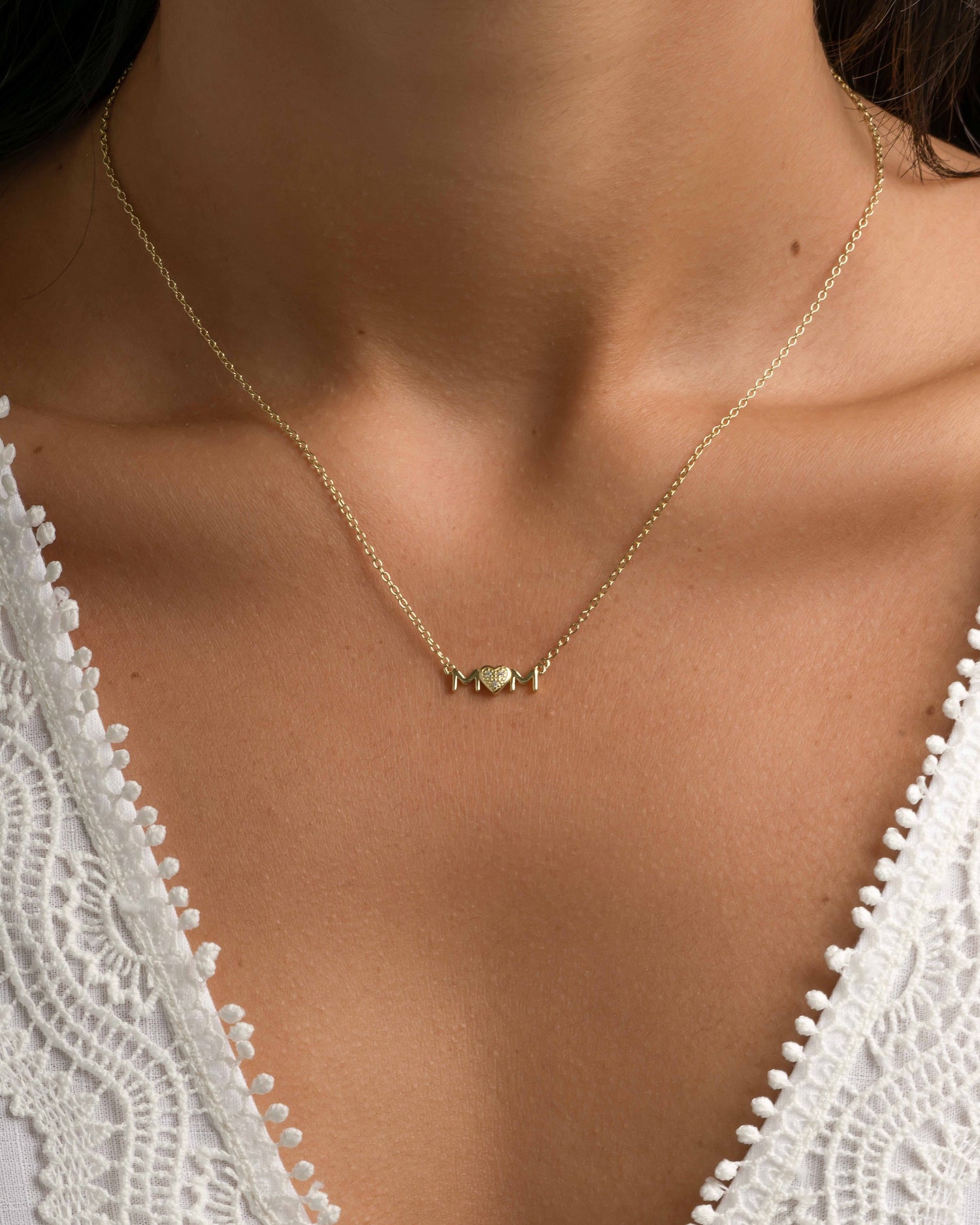 Gold Mom Heart Necklace by Sami Jewels featuring a delicate heart pendant, worn by a model.