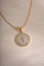 Close-up of Sami Jewels mother of pearl cross necklace in gold, showcasing intricate design and polished surface.
