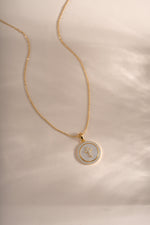 Sami Jewels mother of pearl cross necklace with a delicate pendant on a silver chain, showcasing elegant jewelry design.