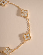 Gold bracelet with a four-leaf clover charm featuring mother-of-pearl and cubic zirconia details by Sami Jewels.