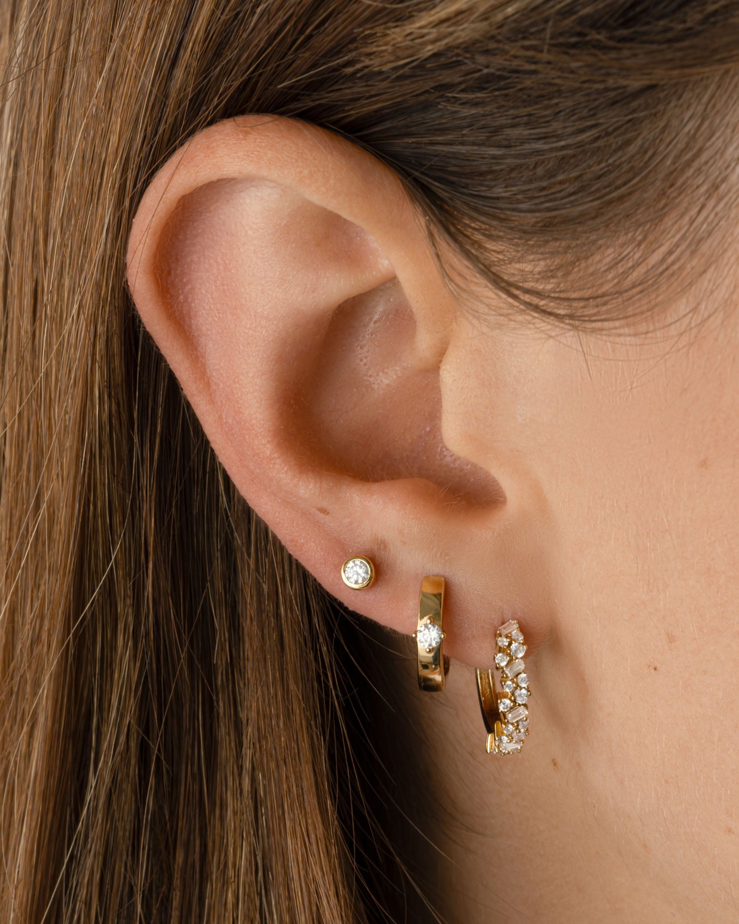 Gold Sami Jewels multi-stone diamond hoop earrings featuring small, sparkling stones in a huggie hoop design.