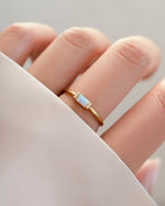 Gold Opal Baguette Ring by Samijewels-527 worn on a model showcasing its elegant design and sparkling gemstone.