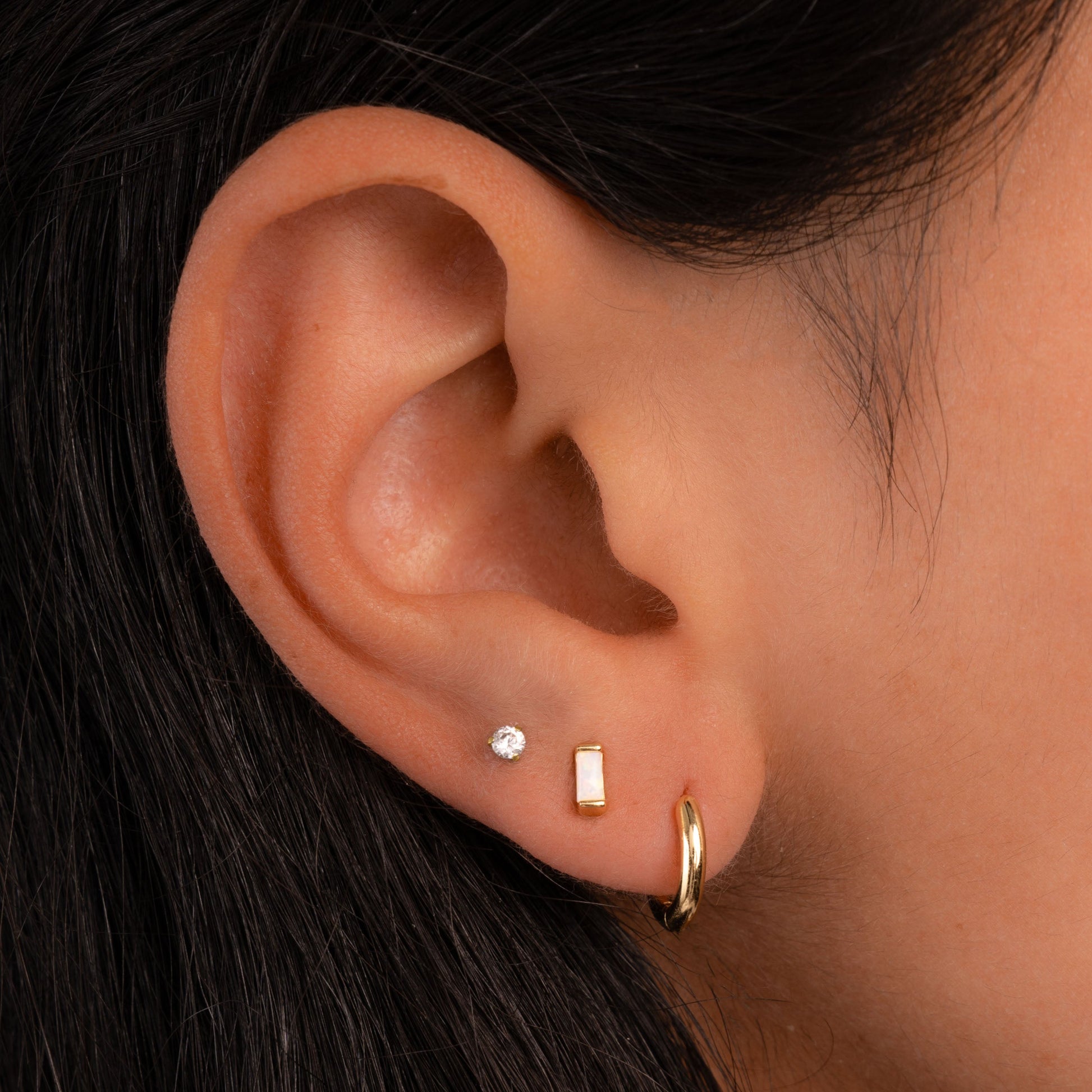 closeup of gold earrings featuring opal earrings 