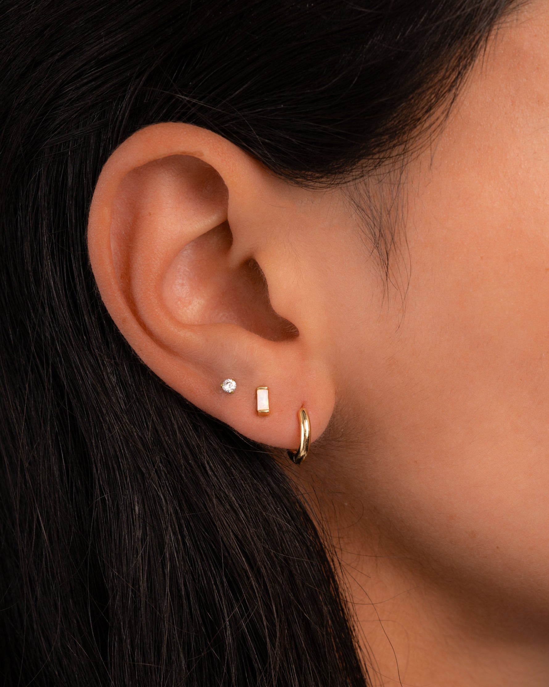 opal baguette stud earring stack in gold on models ear 